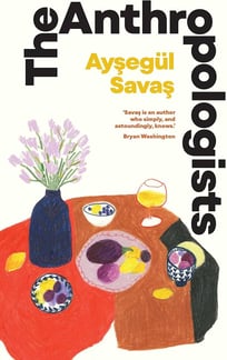 This cover depicts a table set for a meal with plates of food, drawn with large solid colors.